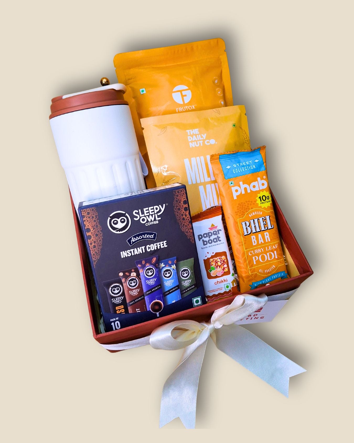 Gift set with coffee, snacks, and a thermos on a beige background