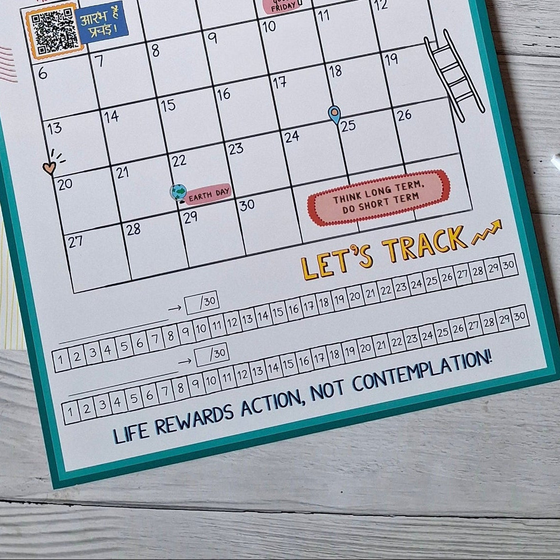 Calendar pages for April and October on a wooden surface with habit tracker