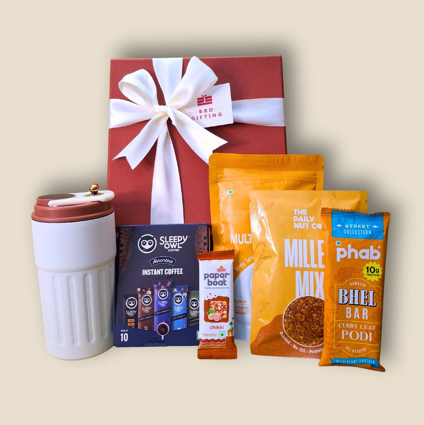 Gift set with a mug, coffee packets, and a red gift box on a beige background