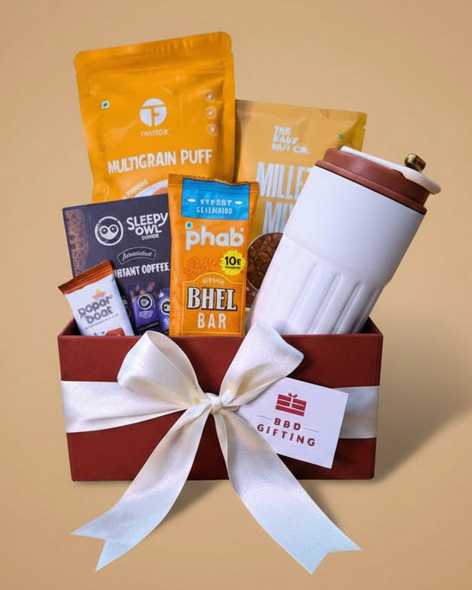Gift basket with snacks, a coffee mug, and a bar of chocolate on a beige background